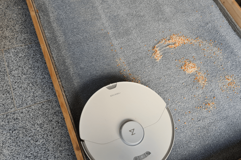 Roborock S7 Pro Ultra vacuum robot cleans oatmeal on a high pile carpet.